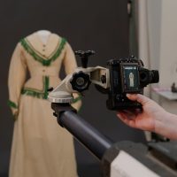 Digital camera on salon stand photographing a nineteenth century dress