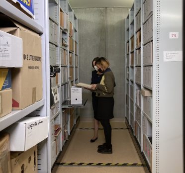 Two women looking through compactus files